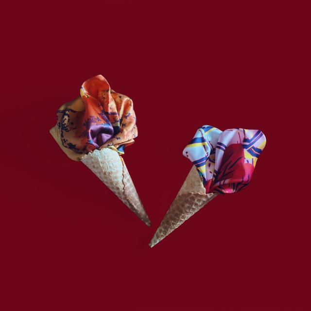 Blue Croata scarf presented in an ice cream cone shape on a red background